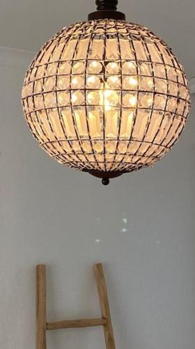 a lamp hanging from a ceiling with a chair underneath it at Maison de Marcel Big house near centre free parking in Bruges