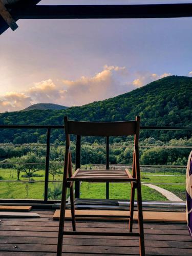 a wooden chair sitting on a porch with a view at Villa Opir in Skole