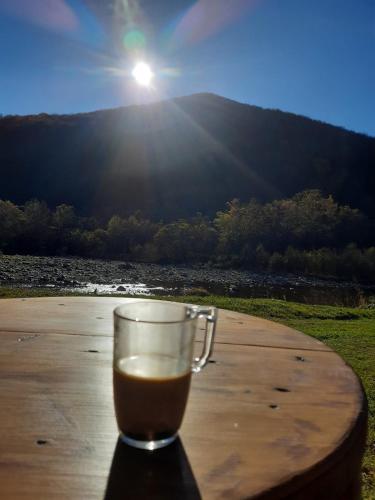 a cup of coffee sitting on a table in front of the sun at Villa Opir in Skole