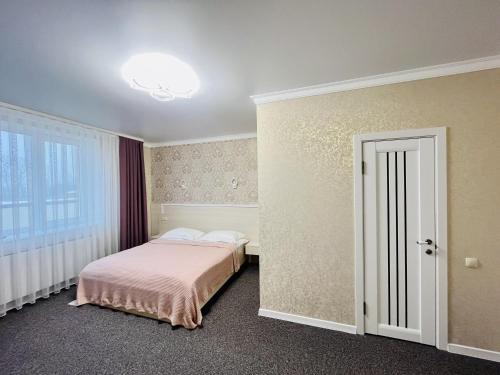 una camera con un letto e una coperta rosa di Готель Лаванда a Chmel'nyc'kyj
