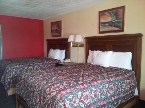 a hotel room with two beds and two lamps at Garden Inn and Extended Stay in Shepherdsville