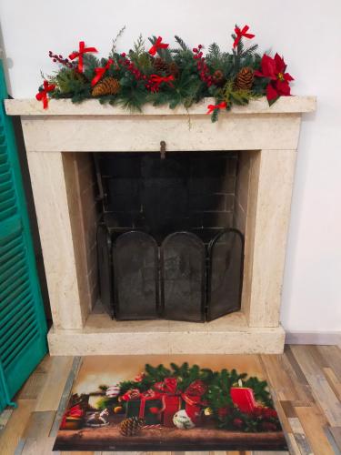 a fireplace with a christmasreath on top of it at BnB La Casina dei Nonni in Campofilone