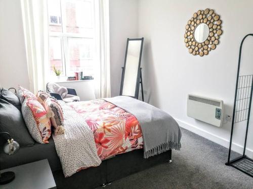 a bedroom with a bed and a mirror on the wall at Stylish & Cosy Abode with FREE parking. in Liverpool