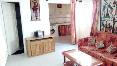 a living room with a red couch and a table at Appartements F2 & F3 à louer Ouest-Foire Dakar in Dakar