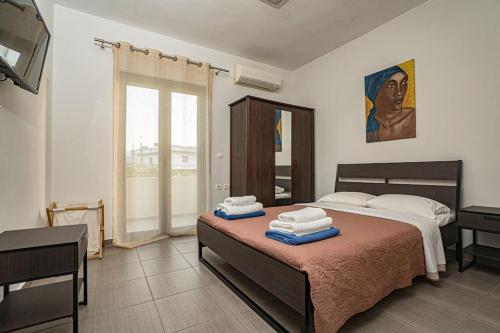 1 dormitorio con 1 cama con toallas en Villa Detoro, en Kambánion