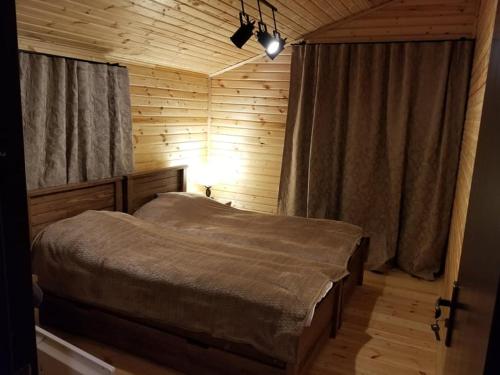 ein Schlafzimmer mit einem Bett in einem Holzzimmer in der Unterkunft Villa GabLile in Mestia