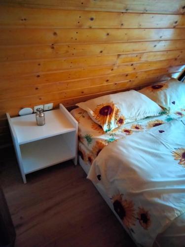 a bedroom with a bed with a wooden wall at Popasul Dacilor in Predeluţ