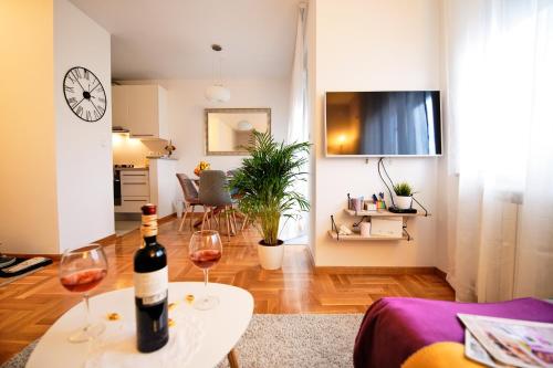 a living room with a bottle of wine on a table at Lovely apartment MIRA near Airport Zagreb in Velika Gorica