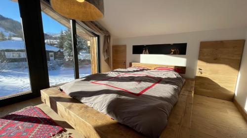 a bedroom with a large bed with a large window at Chalet de l’Alpette in Valloire