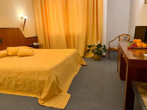 a hotel room with a bed and a table with oranges on it at Hotel Cangrande Di Soave in Soave