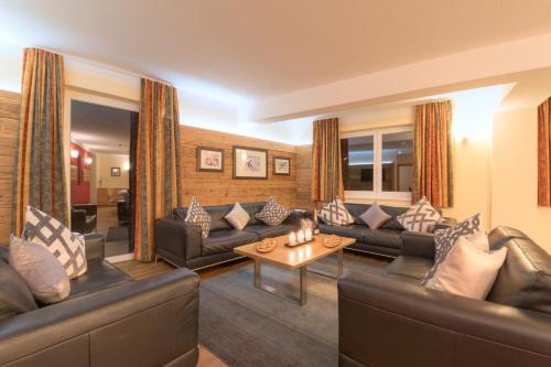 a living room with couches and a coffee table at Chalet Gamskar in Sankt Anton am Arlberg