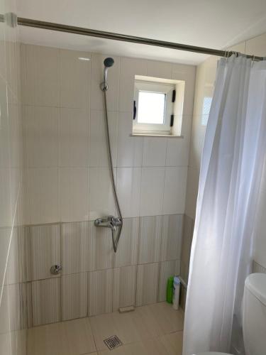 a bathroom with a shower with a shower curtain at Cozy GuestHome Korce in Korçë