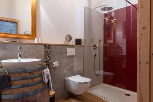 a bathroom with a sink and a toilet and a shower at Chalet Diognysos B&B, Boutique Hotel & Wellness in Crans-Montana