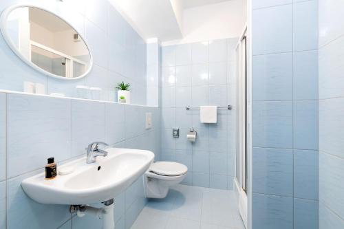 a bathroom with a toilet, sink, and shower at Hotel Plus in Bratislava