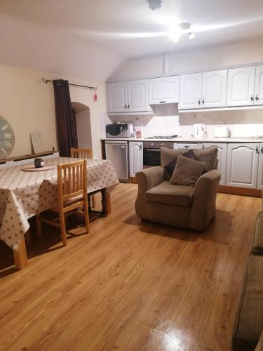 a living room with a table and a couch and a kitchen at Barrow mews views in Carlow