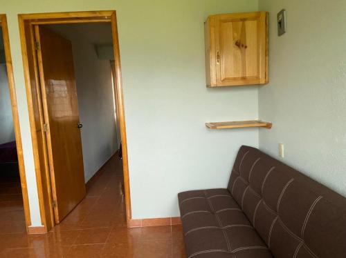 a living room with a couch and a wooden door at Departamento con gran área verde in Zacatlán