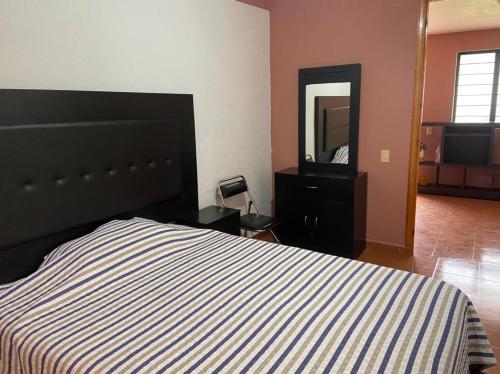 a bedroom with a bed and a dresser and a mirror at Departamento con gran área verde in Zacatlán