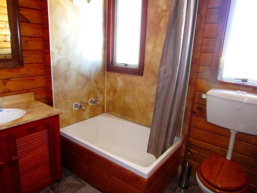een badkamer met een bad, een toilet en een wastafel bij Hanmer Backpackers in Hanmer Springs
