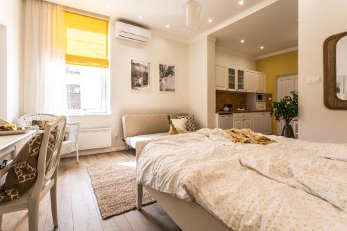 Il comprend une chambre avec un grand lit et une cuisine. dans l'établissement Sweet Dream Apartman, à Pécs