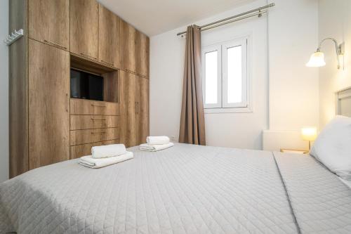 a bedroom with a white bed with towels on it at Anius Apartments in Mýkonos City