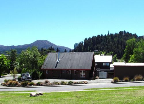 a red barn with a mountain in the background at Hanmer Backpackers in Hanmer Springs