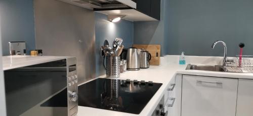 a kitchen with a sink and a black counter top at The Metalworks by Ritual Stays in Hemel Hempstead