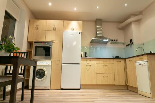 a kitchen with a white refrigerator and a dishwasher at Brassy apartment in Riga
