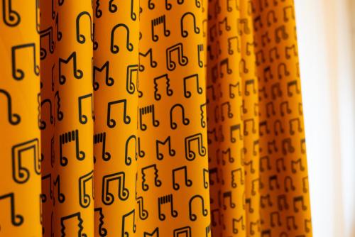 a bunch of music notes on a yellow curtain at ibis Styles Nancy Centre Gare in Nancy
