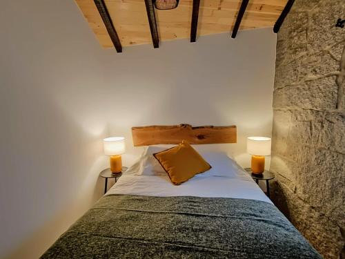 a bedroom with a bed with two lamps on both sides at Casa Ribeiro in Sabugueiro