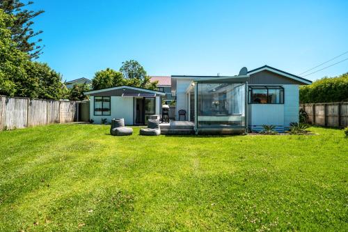 a small home with a glass house in a yard at Bach 14 - Stay Waiheke in Blackpool