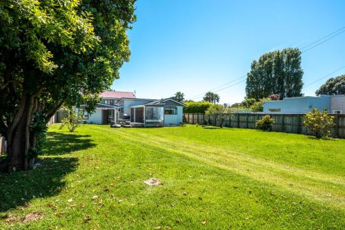 a yard with a house and a fence at Bach 14 - Stay Waiheke in Blackpool