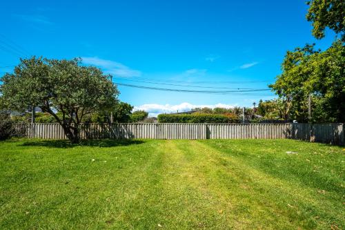 a yard with a fence and a tree at Bach 14 - Stay Waiheke in Blackpool