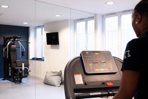 a person riding a treadmill in a room with a mirror at ibis Styles Nancy Centre Gare in Nancy