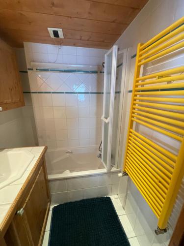 y baño con ducha y bañera. en Appartement ski aux pieds dans résidence premium piscine, sauna hamam en Les Menuires