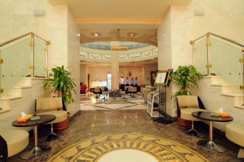 a lobby of a hotel with tables and chairs at Dar Al Naem Hotel in Al Madinah