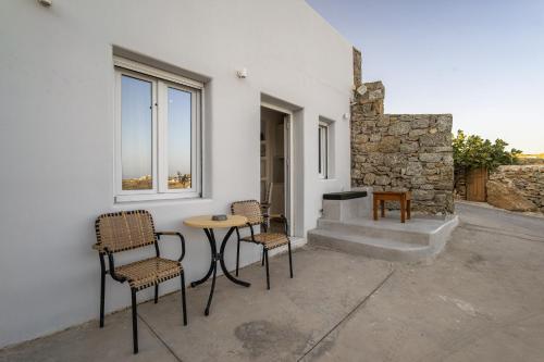 a group of chairs and a table in front of a building at Anius Apartments in Mýkonos City