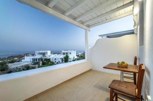 a balcony with a table and a view of the city at Anius Apartments in Mýkonos City