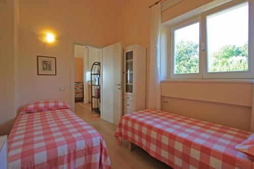 a bedroom with two beds and two windows at Villa Stauder in Genzano di Roma