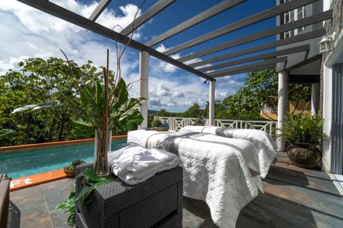 a patio with two beds and a swimming pool at Villa Thompson in Gros Islet