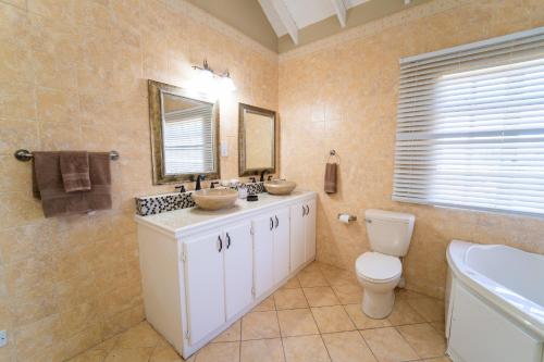 a bathroom with two sinks and a toilet at Villa Thompson in Gros Islet
