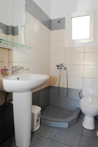 a bathroom with a sink and a toilet at Vythos in Adamas