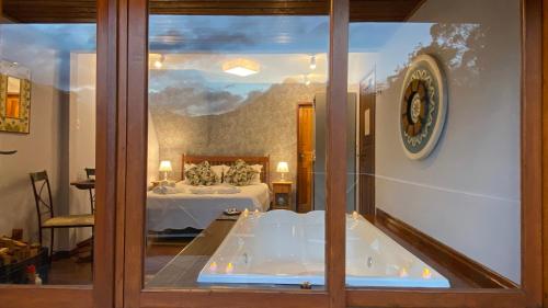 a view of a bedroom with a tub in a room at Pousada Portal Dos Ventos in Visconde De Maua