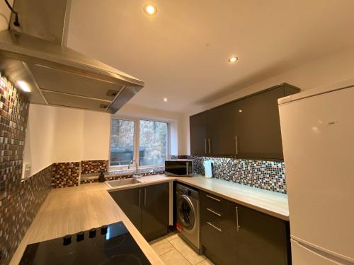 uma cozinha com armários pretos e uma máquina de lavar roupa em Spacious City Centre Property em Lancaster