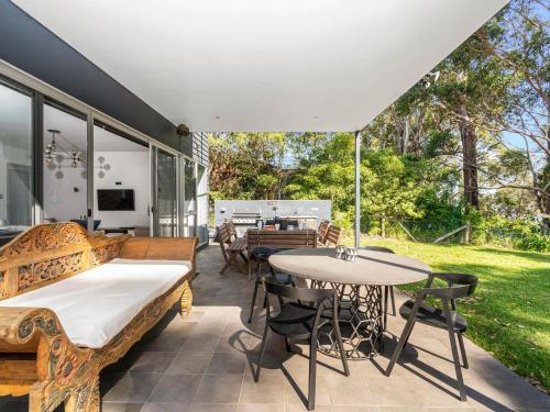 an outdoor patio with a table and chairs at Rigel by Experience Jervis Bay in Vincentia