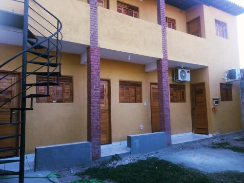 a building with a spiral staircase in front of it at Casa do Mochileiro Airport Hostel & Pousada in São Gonçalo do Amarante