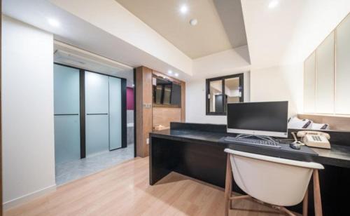 a office with a desk with a computer on it at HOTEL701 Masan in Changwon