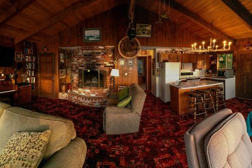 a living room with couches and a kitchen and a fireplace at Panoramic Promontory: Bay View Beach House in Waldport
