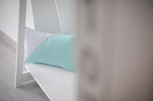 a white bench with a blue pillow on it at ArouceHostel in Lousã