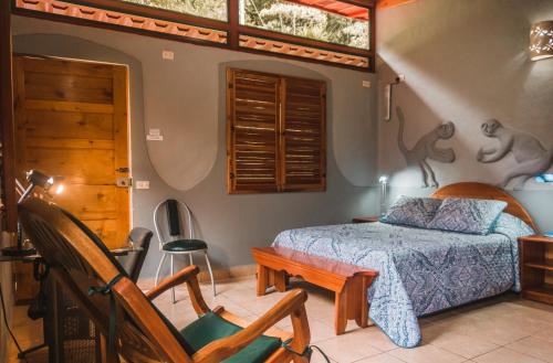 a bedroom with a bed and a chair at Talamanca Nature Reserve in Rivas