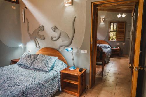 a bedroom with a bed and some animals on the wall at Talamanca Nature Reserve in Rivas